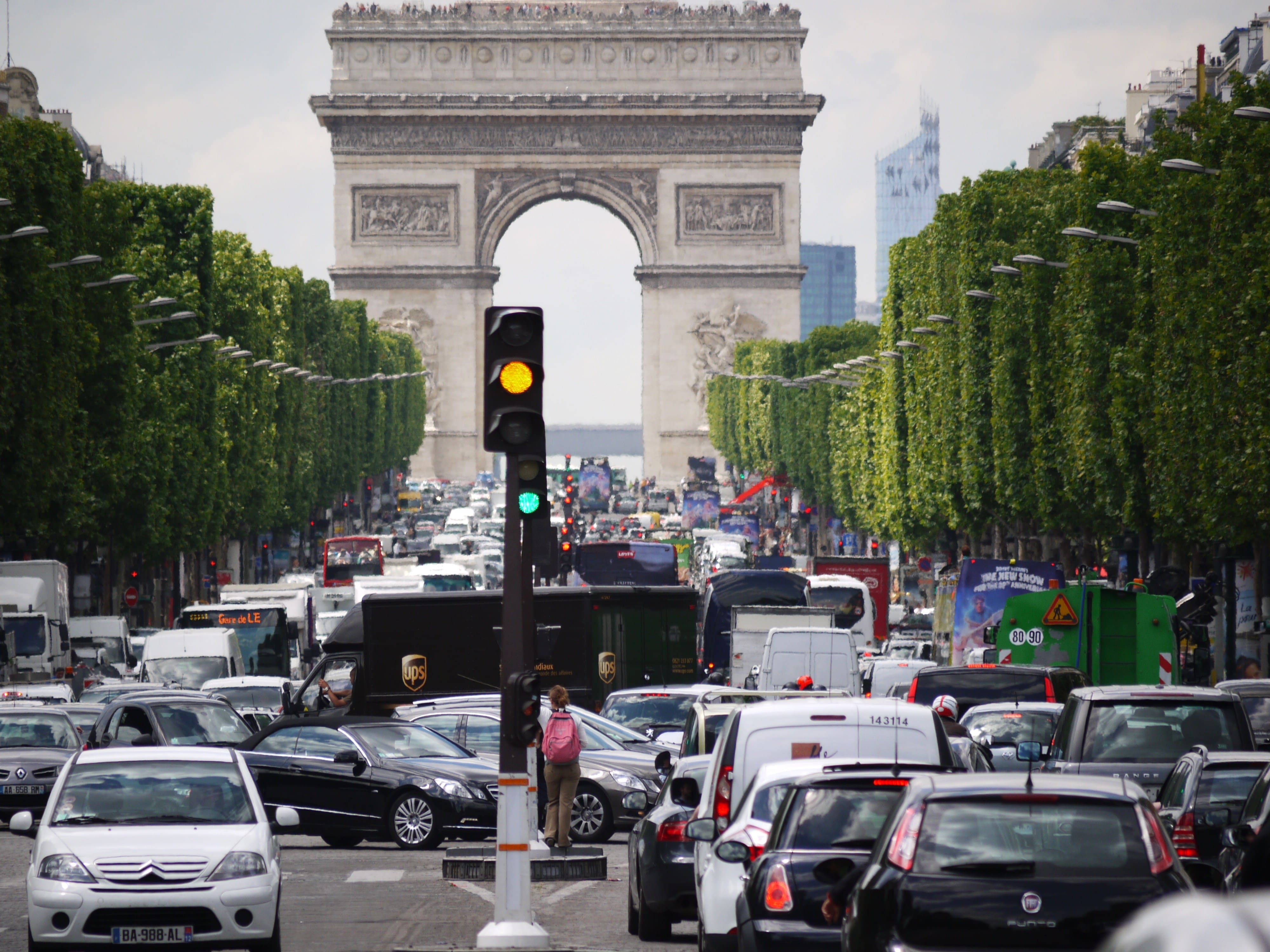 Congestion in front of the Arc de Triomphe in Paris, France. A traffic light is orange