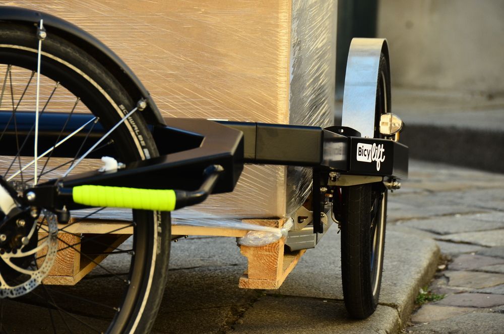 Urban transport Rear wheel of a bike with a BicyLift bike trailer with carton boxes on it attached to the bike
