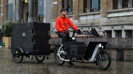 Livreur à vélo avec veste rouge tractant une remorque BicyLift et un conteneur isotherme ROll O'City