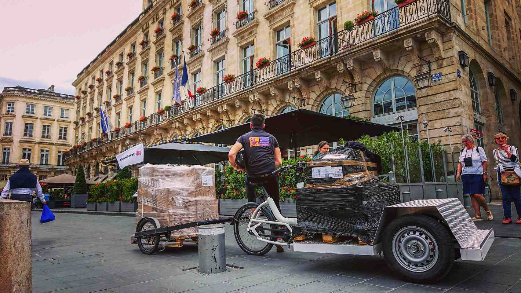 Urban Arrow tender bike with a BicyLift bike trailer attached to it transporting an EU pallet in front of a French building