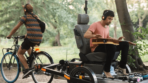 Person playing guitar on a Flatbed and a BicyLift bike trailer pulled by a Swapfiets bicycle