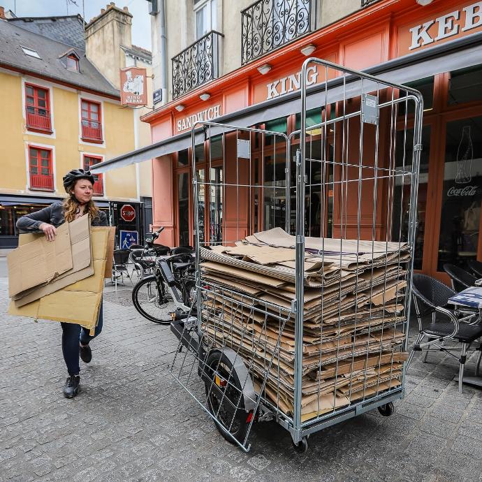 Collecte de carton par une livreuse en centre ville