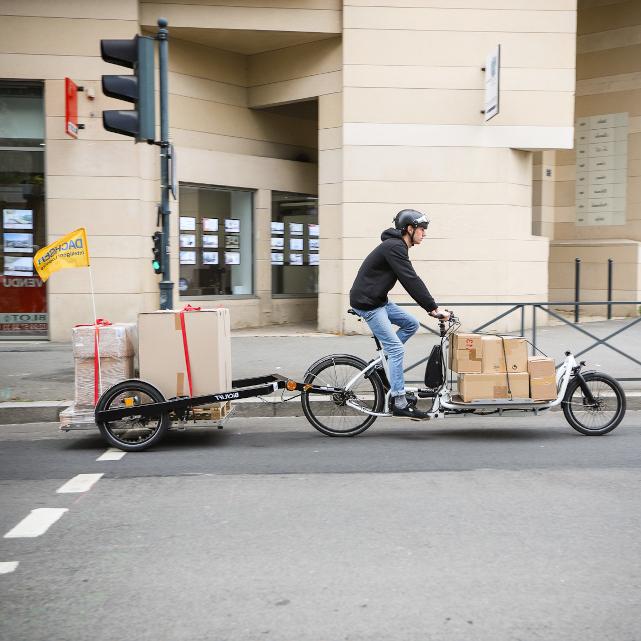 Bike courier on a Douze V2 bike pulling a BicyLift trailer and a Flatbed