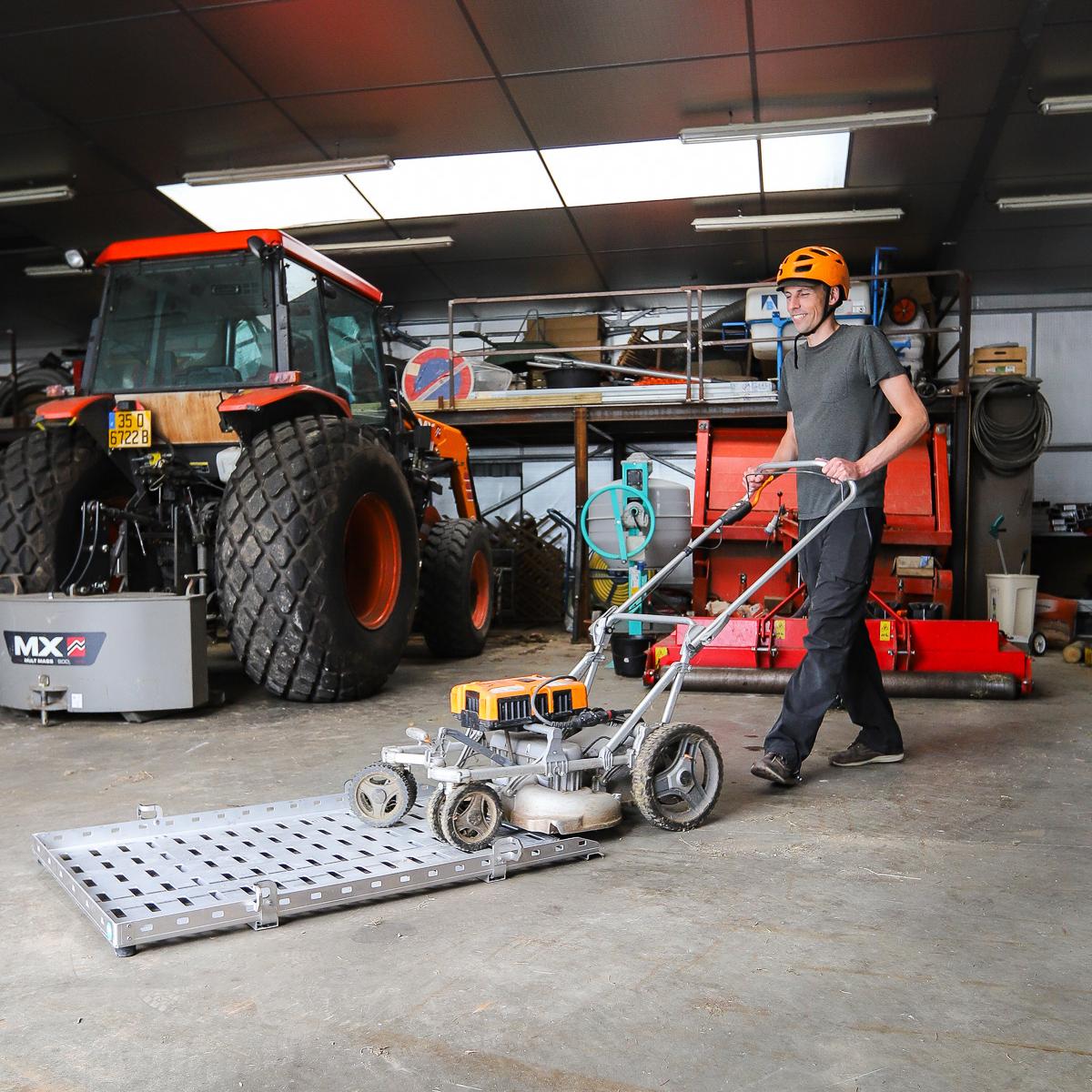 Landscaper using the Flatbed to load a lawnmower
