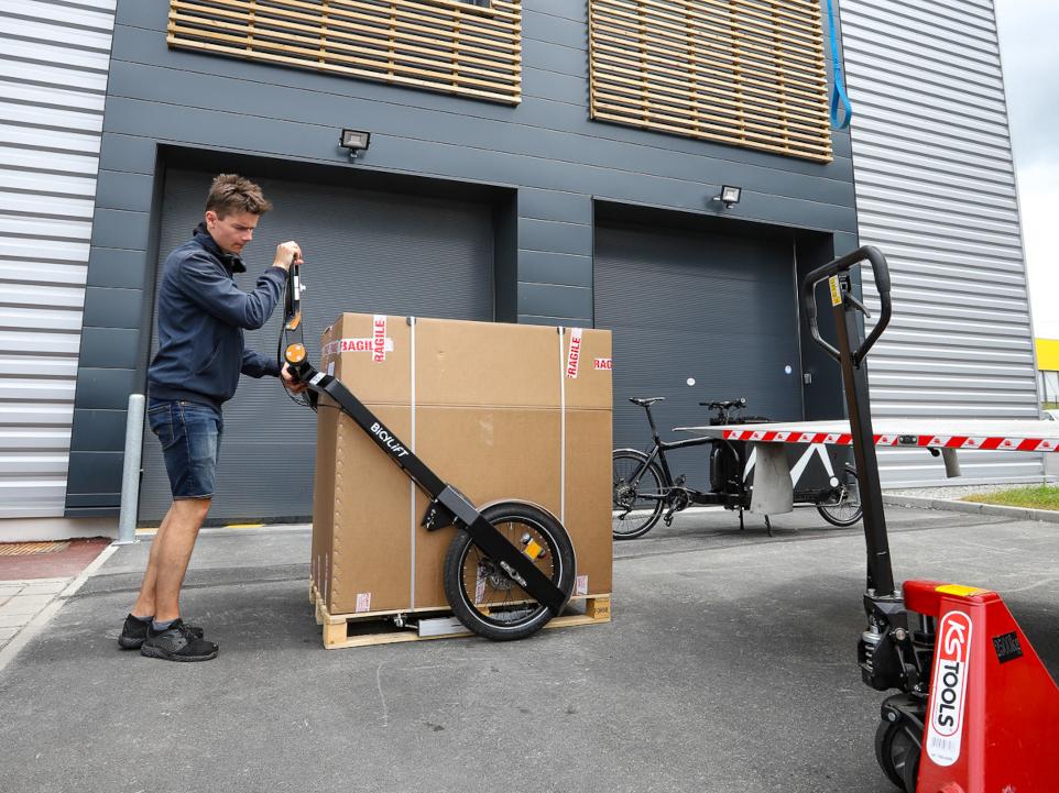 Man lifting a pallet with the BicyLift bike trailer