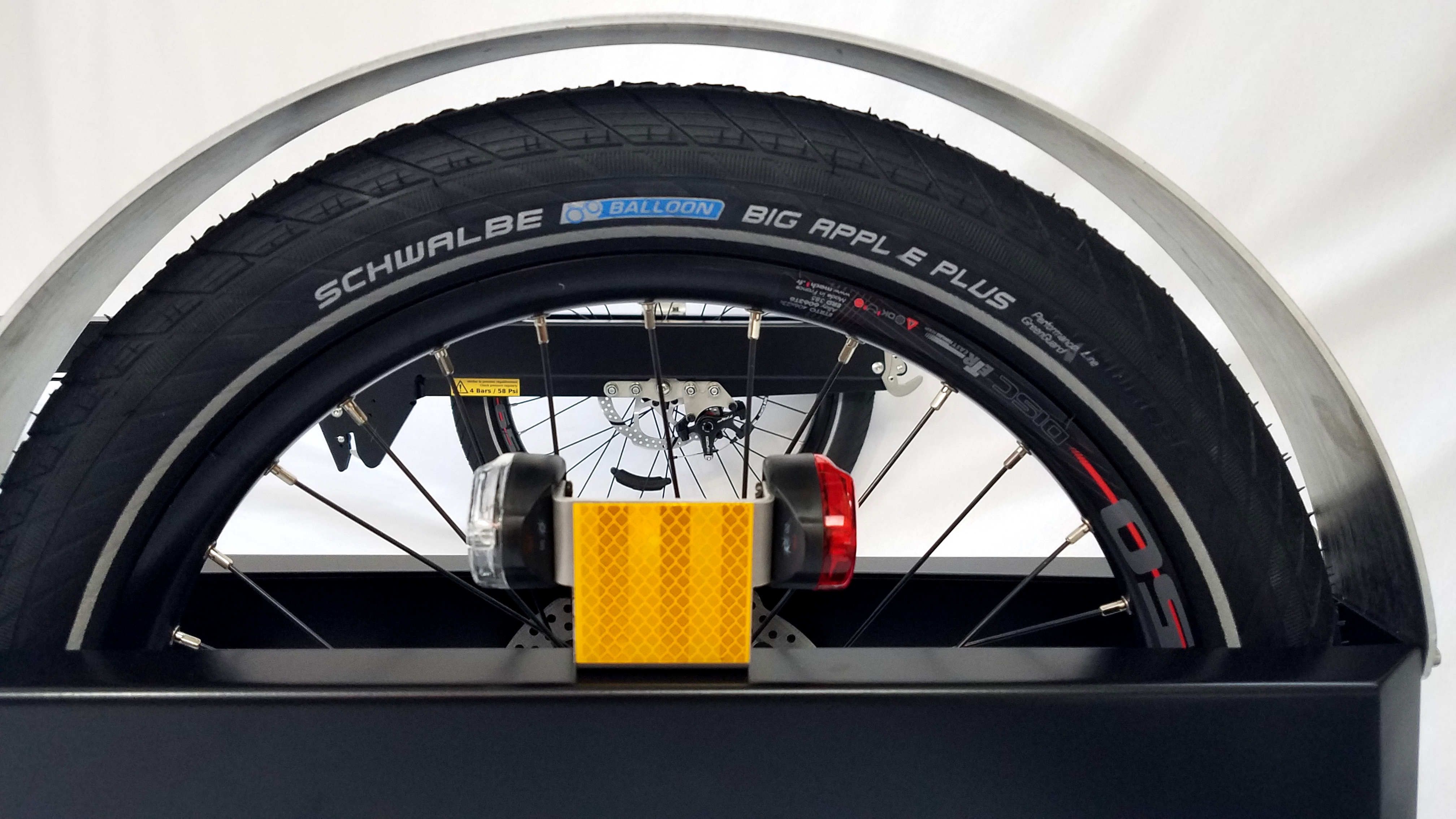 Lighting Half of a wheel of the BicyLift bike trailer with a red and white light with an orange reflector